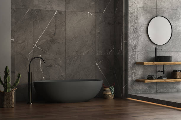 istock A modern bathroom with a minimal wooden vanity, oval mirror, black sink, marble ceramic walls, concrete floor, plants and baskets, bathroom accessories, and a modern anthracite bathtub. 3d rendering 1485428752