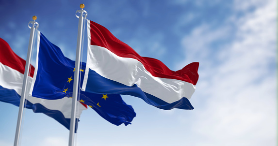 The flags of the Netherlands and the European Union waving in the wind on a clear day. The Netherlands became a member of the EU in january 1958. 3d illustration render. Fluttering fabric