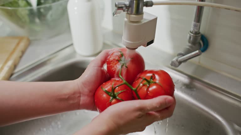 Close-up Washing Tomato vegetables in kitchen