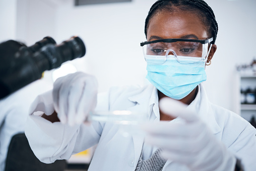 Science, covid and solution with a black woman doctor working in a laboratory for research or innovation. Medical, analytics and development with a female scientist at work in a lab for chemistry