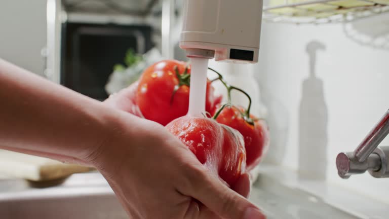 Close-up Washing Tomato vegetables in kitchen