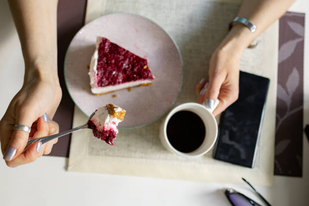 istock Women siting in caffe eating slice of raspberry cheesecake 1485441590