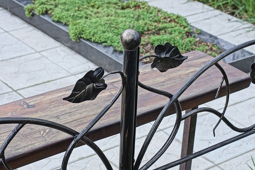 part of a black metal decorative fence made of iron bars at the grave in the cemetery