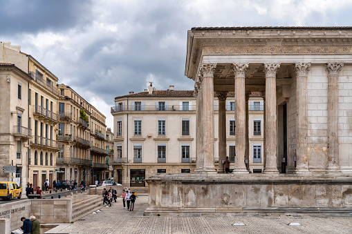 April 26, 2023: Maison Carrée, the Roman temple in Nimes, France. Photo taken during a warm spring afternoon and contains some people.
