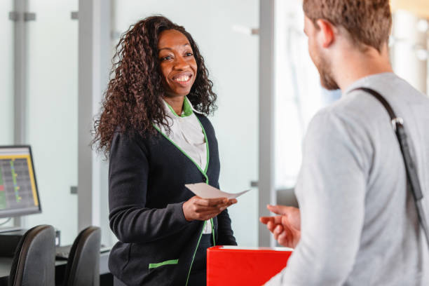 istock Friendly Mid-Adult African Air Stewardess Checking A Passenger Boarding Pass 1485451417