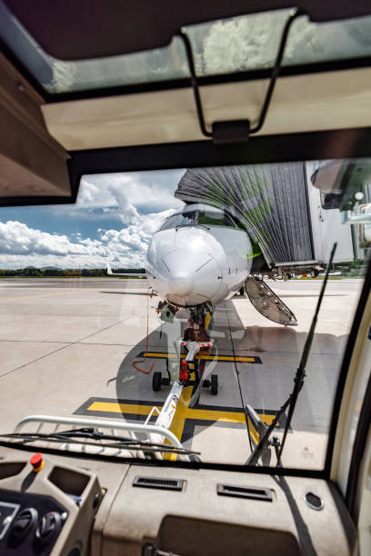 attraverso il finestrino aereo commerciale con ponte d'imbarco passeggeri - airport window outdoors airfield foto e immagini stock