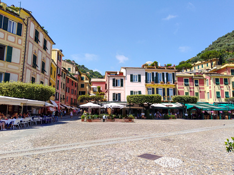 Panoramic view of the fishing village of Portofino and its traditional Ligurian colorful houses, sidewalk cafes, restaurants, and its marina, Liguria, Italy