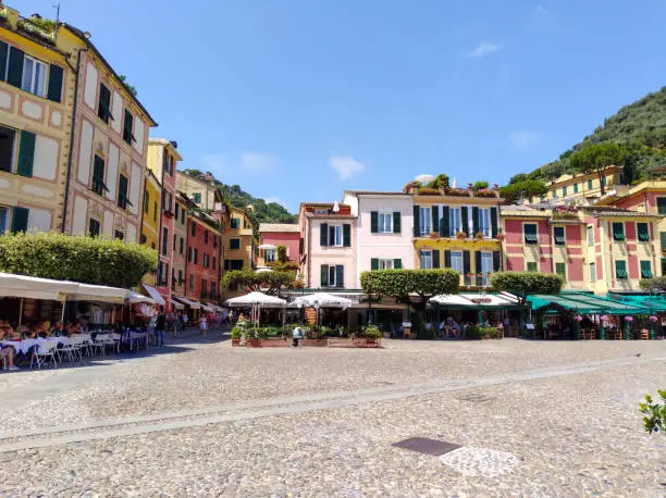Panoramic view of the fishing village of Portofino and its traditional Ligurian colorful houses, sidewalk cafes, restaurants, and its marina, Liguria, Italy