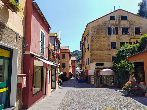 Panoramic view of a narrow alley that leads to the fishing village of Portofino and its traditional Ligurian colorful houses, and its marina, Liguria, Italy