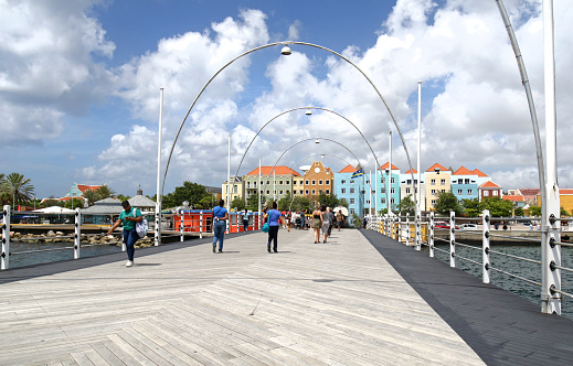 A view of the Queen Emma Bridge, a movable floating pontoon bridge in downtown Willemstad, Curacao. Dramatic Cloudy Sky.