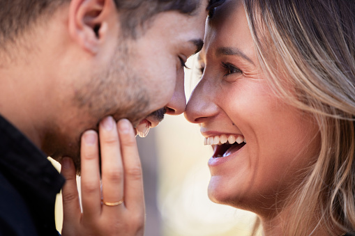 Couple, forehead touch and laugh together with happiness, comic moment or romance outdoor for date. Man, woman and funny time with love, care or happy in nature closeup with hand, face and crazy joke