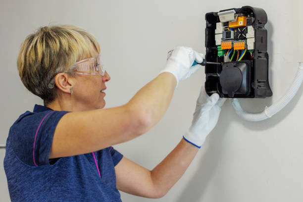 Certified Female Electrician Installing Home EV Charger stock photo