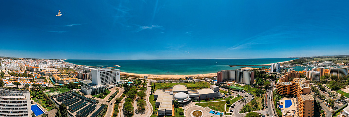 Vilamoura, Algarve, Portugal - April 24, 2023: Aerial drone panoramic view of Vilamoura and Quarteira cities on the Algarve coast of southern Portugal on a sunny day