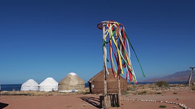 Traditional camp of nomads from yurts is set up on shore of lake Issyk-Kul.
