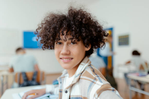 School and Portrait Boy Portrait of boy looking at camera while sitting with his classmates during high school exam lifestyles teaching little girls child stock pictures, royalty-free photos & images