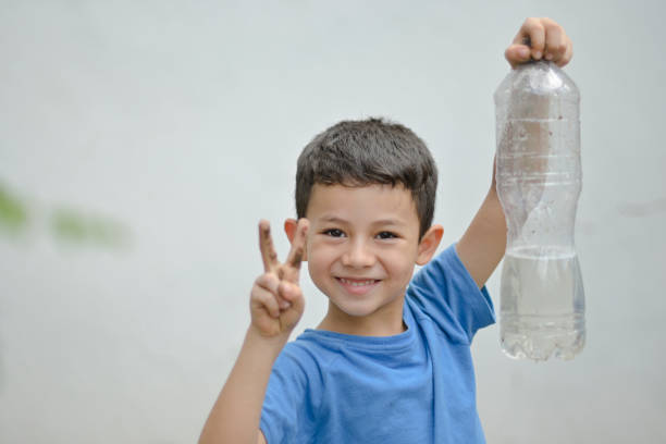 istock boy making a peace sign with his hands, boy holding a bottle with recycled water 1485481387