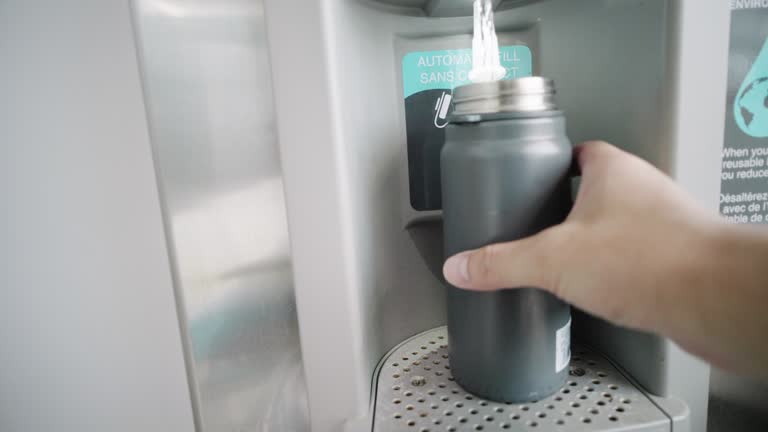 Refilling drinking water in a water bottle in airport terminal