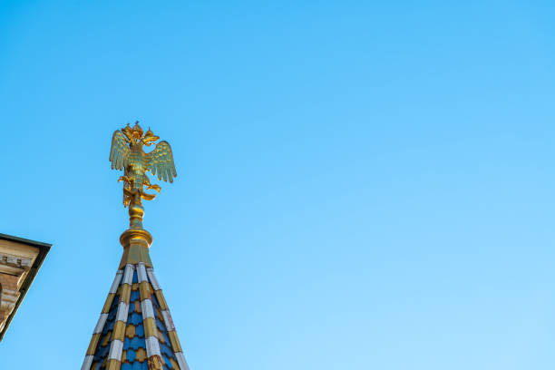 Golden double-headed eagle, coat of arms of Russia, on tower top of Church of the Savior on Spilled Blood in a sunny day in Saint Petersburg city. Clear blue sky. Copy space. National symbols theme.