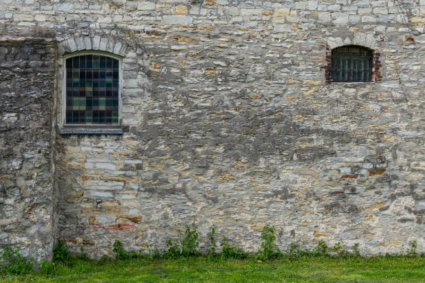 istock Fragment of a gray stone wall with arched windows. 1485491143