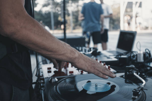 istock Close-Up of DJ's Hand Playing Vinyl Record on Turntable with Blurred Crowd in Background 1485491582