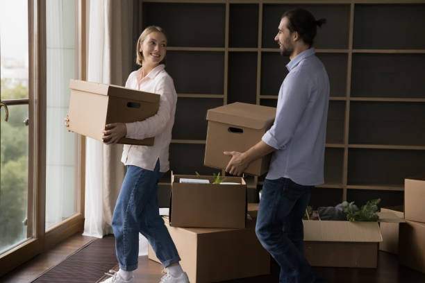 istock Engaged positive millennial couple talking, chatting, laughing, carrying paper boxes 1485496790