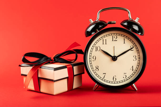 istock gift box and alarm clock on a red background, time for shopping. 1485497634
