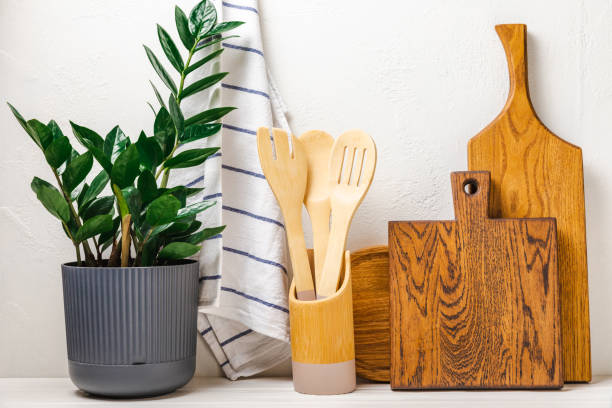 istock Cutting board,kitchenware,dishtowel and flower on white wall background.Modern kitchen background with kitchen utensils standing on wooden tabletop, blank space for text, front view.Recipe.MOCKUP. 1485497809