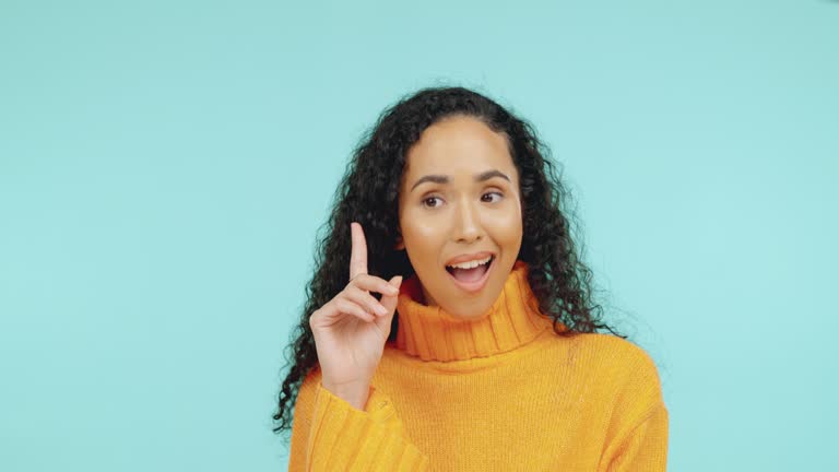 Thinking, happy and eureka with a black woman in studio on a blue background for inspiration or breakthrough. Idea, smile and lightbulb moment with an attractive young female contemplating motivation