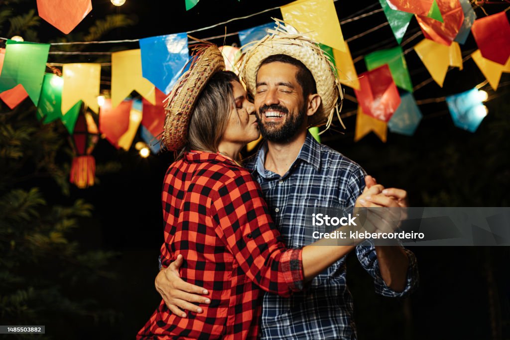 Brazilian couple wearing traditional clothes for Festa Junina - June festival - dancing under the night sky Festa Junina Stock Photo