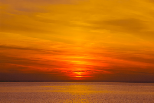 background image: setting sun on the horizon over the water surface