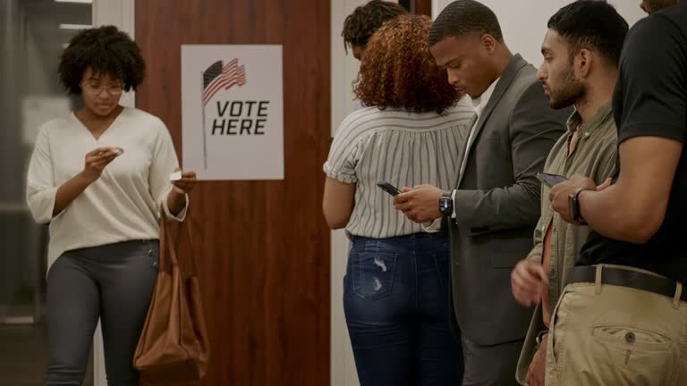 Young woman places 'I Voted' sticker on her shirt after voting in general election