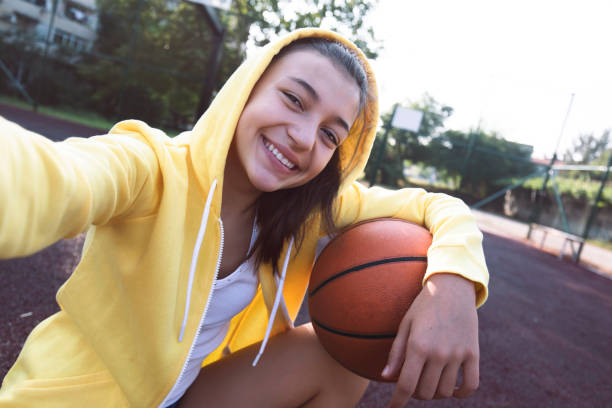Teenage girl practicing basketball stock photo