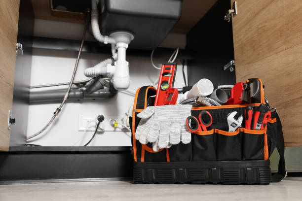 Plumber's tool bag on floor under kitchen sink Plumber's tool bag on floor under kitchen sink plumbing fixture stock pictures, royalty-free photos & images