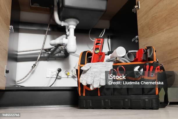 Plumbers Tool Bag On Floor Under Kitchen Sink Stock Photo - Download Image Now - Water Pipe, Repairing, Work Tool