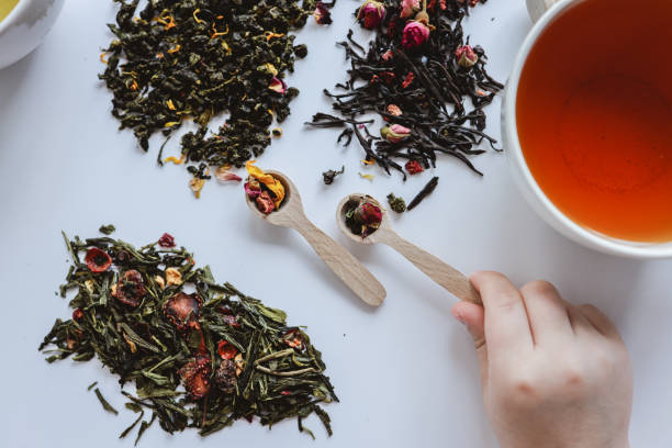 istock Spoon with leaf tea in hands on a white background, tea time 1485513033