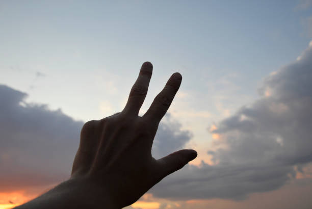 istock hand with a finger symbol against the sky at sunset 1485513712