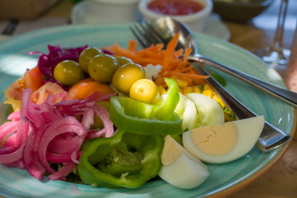 Mediterranean salad in Spain with carrot boiled eggs olives tomato onion green peppers  and lettuce