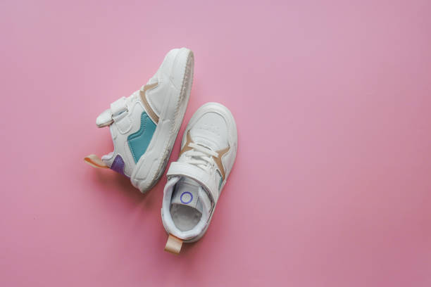 istock White children's sneakers on a pink background with copy space. Banner 1485518019
