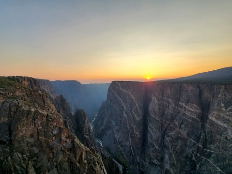 This is a photograph taken on a mobile phone outdoors of sunset over the landscape of Black Canyon of the Gunnison National Park in summer of 2020 in, Colorado USA.