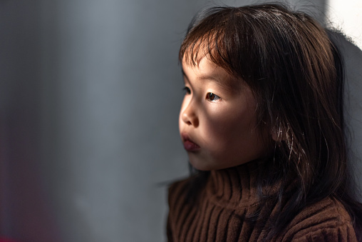 Close-up of an Asian girl in a dimly lit room