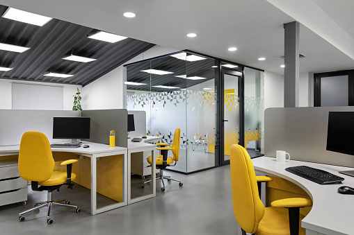 It office with workplaces for employees developers with yellow chairs. Computer for coding room.