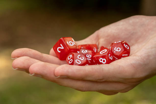 istock Man holding a group of simple red classic RPG game dice, objects held in hand detail, closeup Role playing board games symbol, live action roleplay LARP abstract concept, copy space, one person 1485531904