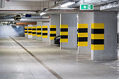 Empty underground parking lot under a modern apartment complex flat, one generic car parked, nobody, no people, lots of free parking space New real estate parking spots buying business, simple concept