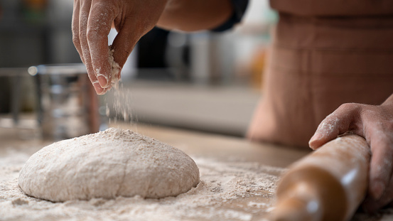 Artisanal bakery: Artisan Chef Hands kneading dough. Artisanal bakery is bread made by a craftsperson using mainly traditional techniques. Also, it is usually made by hand, however, many artisanal bakeries use also electrical mixers and dividers. The bakers who do everything by hand tend to draw a line differently than the bakers who use lots of automated equipment. Artisanal bakery, only made by hand, is part of the romantic and traditional way of cooking from old times.