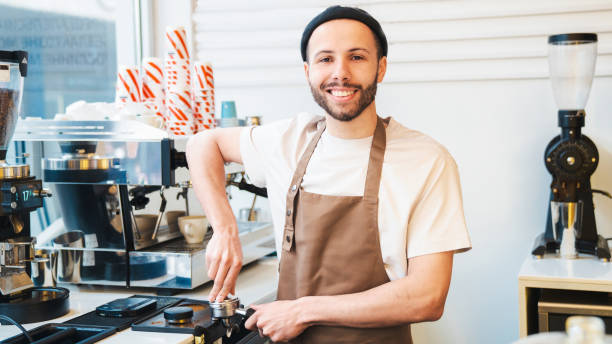 istock Happy barista using a tamper to press ground coffee into a portafilter 1485536189