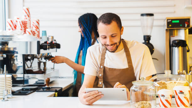 istock Smiling barista typing on tablet screen while accepting online order in coffee shop 1485538366