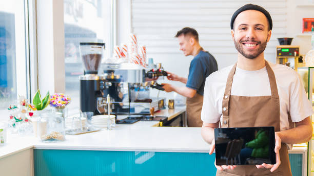 istock Male barista holding tablet, empty screen for copy space 1485539743