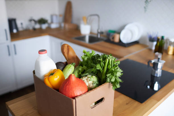 istock Background image of box with fresh groceries in kitchen 1485541760