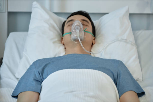 istock Young patient in oxygen mask lying in hospital 1485542693
