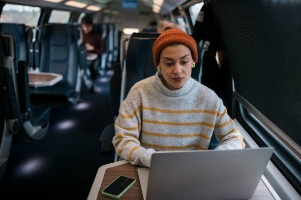 istock Young woman traveler using laptop while travelling by a train 1485543882